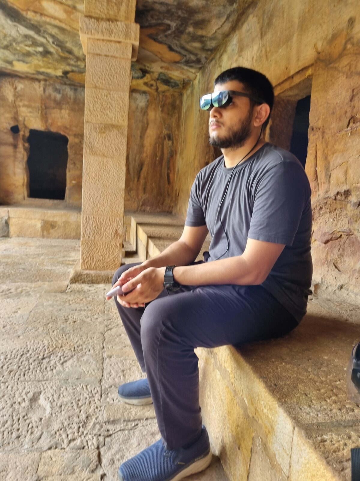 Visitor with AR glasses inside Khandagiri cave chamber