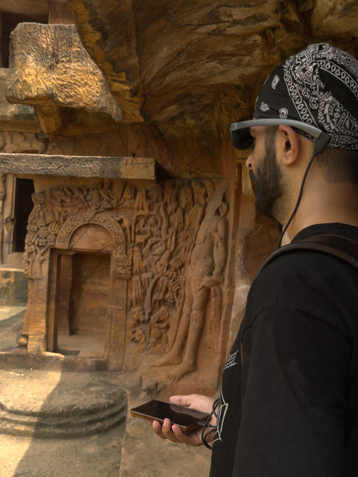 Visitor with AR glasses viewing cave wall carvings