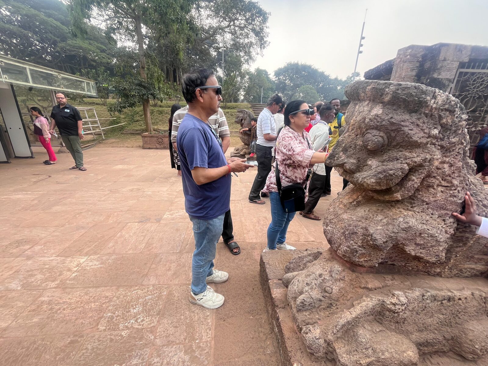 Visitors with AR glasses near stone sculptures at Konark