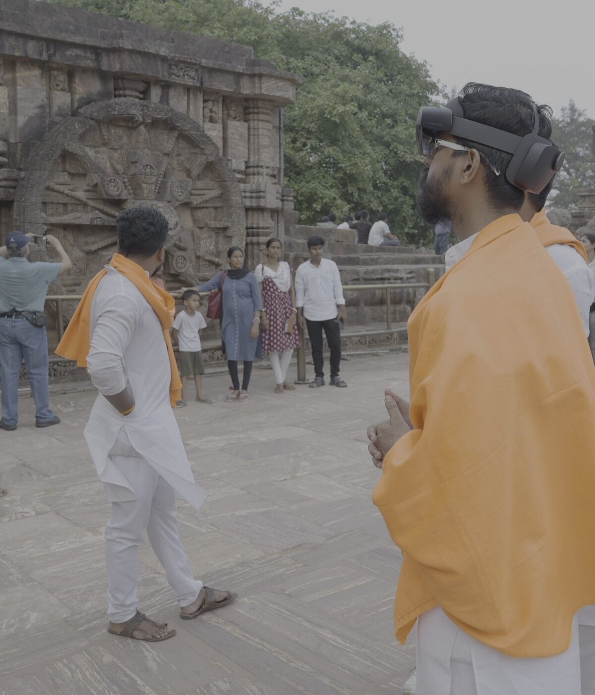 Visitor wearing VR headset near Konark stone wheel